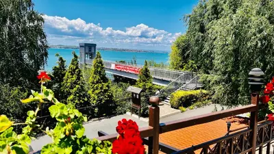 a balcony with a view of the water and a train at Cozy Home Santa Marina Sozopol in Sozopol