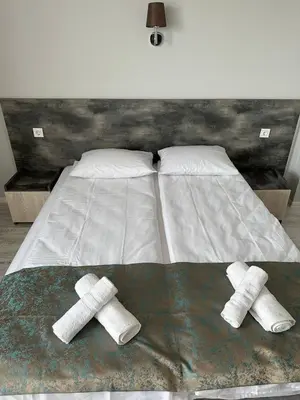 a bed with two pairs of towels on it at Studios and Apartments Pomorie in Pomorie