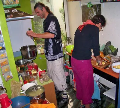 two people standing in a kitchen preparing food at Yo Ho Hostel in Varna City