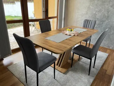 a dining room table with chairs and a wooden table at EGGO APARTMENT - Oasis Beach Apartments Kamchia in Dolen Bliznak
