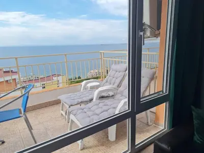 a balcony with two chairs and a view of the ocean at Imperial Fort Club Apartament in Sveti Vlas