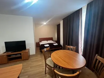 a living room with a table and a television at GT Green Fort Beach Apartments in Sunny Beach
