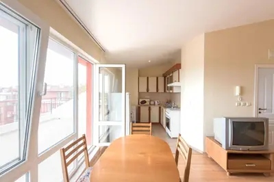 a dining room with a table and a television at GT Green Fort Beach Apartments in Sunny Beach