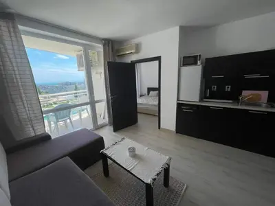 a living room with a couch and a table and a kitchen at Blue Horizon Sarafovo in Burgas City