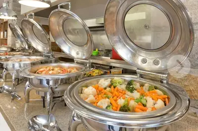 a row of trays of food in a kitchen at Dream Cascadas - Слънчев бряг in Sunny Beach