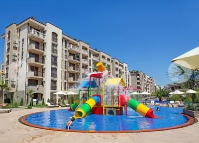 a child on a water slide in a pool at Dream Cascadas - Слънчев бряг in Sunny Beach