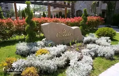 a garden in front of a building with flowers at Dream Cascadas - Слънчев бряг in Sunny Beach