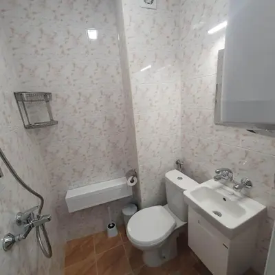 a bathroom with a white toilet and a sink at Apartment Voivoda in Varna City