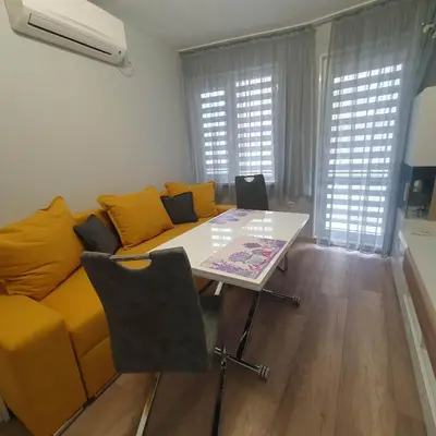a living room with a yellow couch and a table at Apartment Voivoda in Varna City