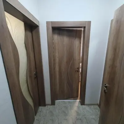 a hallway with two wooden doors in a room at Apartment Voivoda in Varna City