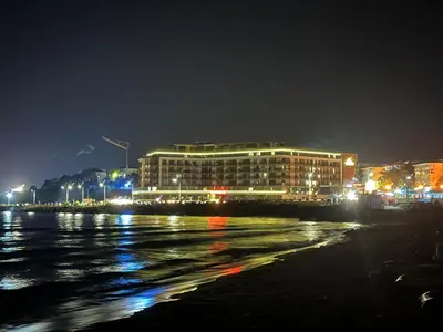a building on the shore of the water at night at Sea View Private Studio Paradiso B 508 in Nesebar