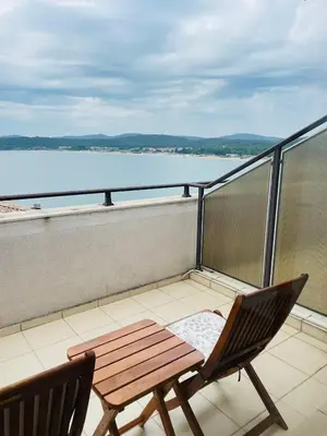 a balcony with a wooden table and two chairs at Вила Дафни - Villa Dafni in Sozopol