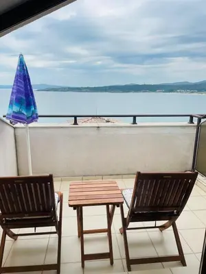 two chairs and a table on a balcony with a view of the water at Вила Дафни - Villa Dafni in Sozopol