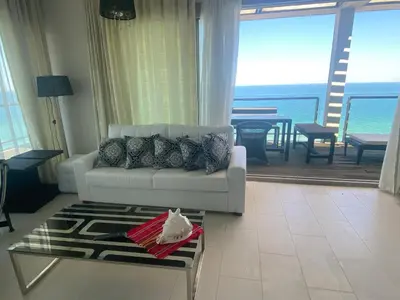 a living room with a couch and a view of the ocean at Private Apartments in Yoo Bulgaria Complex in Obzor