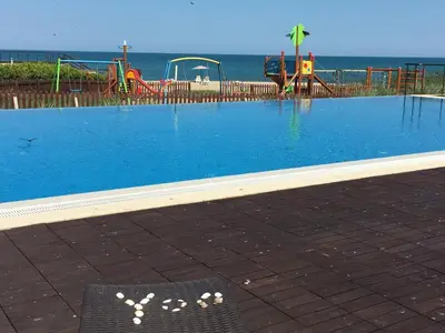 an empty swimming pool with a playground in the background at Private Apartments in Yoo Bulgaria Complex in Obzor