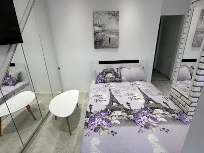 a bedroom with a bed with a purple bedspread at Lovely studio in Burgas in Burgas City