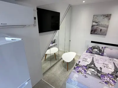 a small bedroom with a bed and a tv at Lovely studio in Burgas in Burgas City