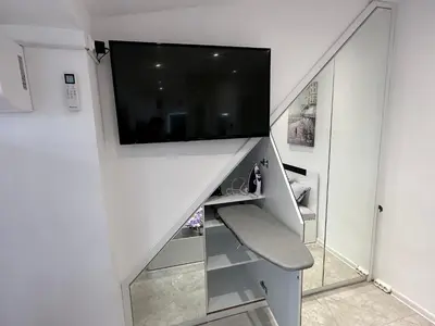 a living room with a staircase with a tv at Lovely studio in Burgas in Burgas City