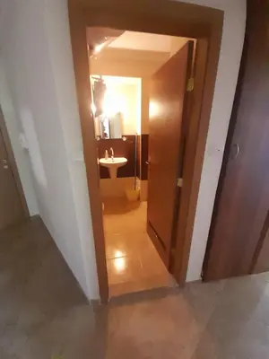 a hallway with a door leading to a bathroom with a sink at YASSEN APARTMENT CLOSE TO SEA And Central in Sunny Beach