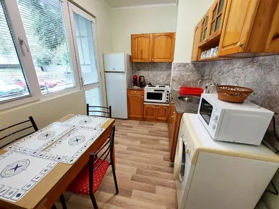 a kitchen with a table and a white microwave at Апартамент за гости, ж.к. Зорница , бл.9 in Burgas City