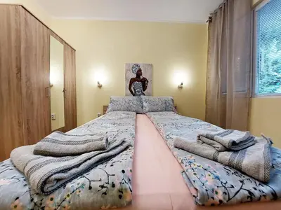 a bedroom with a large bed with blankets on it at Апартамент за гости, ж.к. Зорница , бл.9 in Burgas City