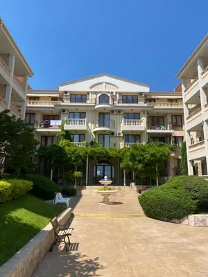 a large building with a picnic table in front of it at ROYAL BAY 6 Sea View Apartment in Sveti Vlas