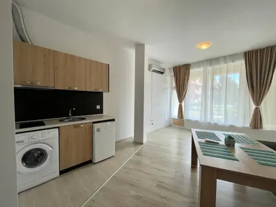 a kitchen with a washing machine and a table at Sveti Vlas - Central Beach Studio by Flat Mаnаger in Sveti Vlas