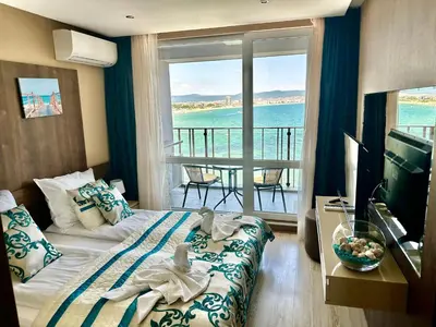 a hotel room with a bed and a view of the ocean at One Bedroom Private Apartment Paradiso B 501 in Nesebar