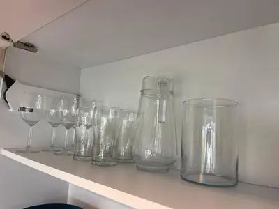 a row of clear glasses sitting on a shelf at Panoramic apartment in Varna with underground parking in Varna City