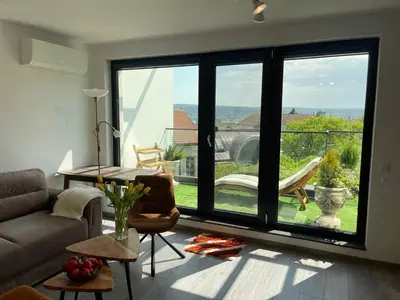 a living room with a couch and a large window at Panoramic apartment in Varna with underground parking in Varna City