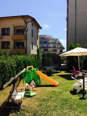 a playground with a slide in the grass at SannyBeach AmberBeach Apartment Bulgaria A14-1 in Sunny Beach