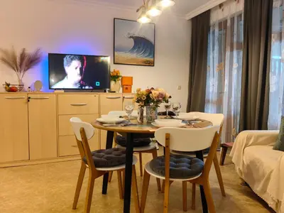 a dining room with a table and chairs and a tv at Нощувки Свети Влас Комплекс Амфора , студио 704 in Sveti Vlas