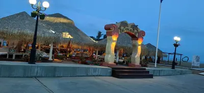 a resort with an arch and tables and straw umbrellas at Нощувки Свети Влас Комплекс Амфора , студио 704 in Sveti Vlas