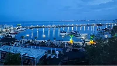 a view of a marina at night with boats in the water at Нощувки Свети Влас Комплекс Амфора , студио 704 in Sveti Vlas