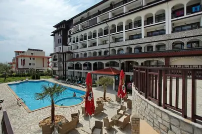a hotel with a swimming pool in front of a building at Нощувки Свети Влас Комплекс Амфора , студио 704 in Sveti Vlas