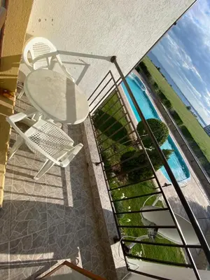 a balcony with a table and chairs and a pool at RUTLAND BEACH C8 Two Bedroom Apartment Ravda in Ravda