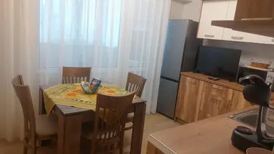 a kitchen with a table with chairs and a television at Deni's Apartment by the sea – Burgas in Burgas City
