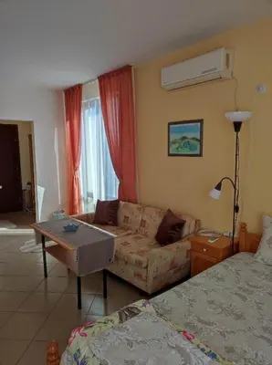 a living room with a couch and a bed at Студио Слънчево утро in Burgas City