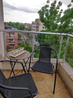 a balcony with two chairs and a table on a balcony at Студио Слънчево утро in Burgas City