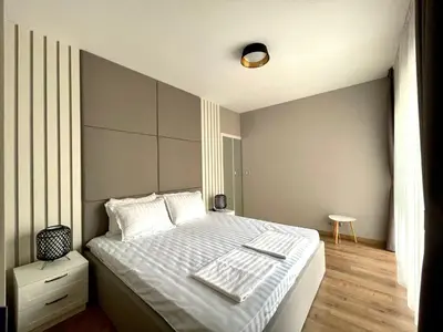 a bedroom with a large bed with white sheets at Open Sea Panorama Residence in Obzor