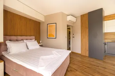 a bedroom with a large bed with white sheets at Open Sea Panorama Residence in Obzor