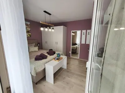 a bedroom with purple walls and a bed and a mirror at AMORE Obzor in Obzor