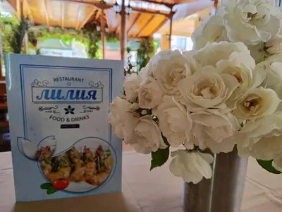 a vase filled with white flowers next to a box at AMORE Obzor in Obzor