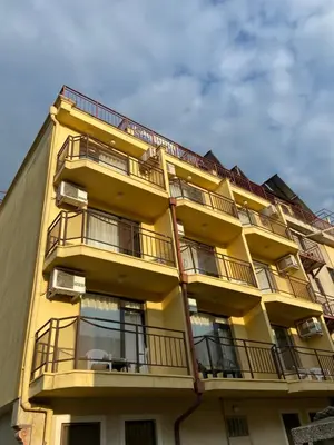 a yellow building with balconies on the side of it at Хотел ЗОНАРИТА in Primorsko