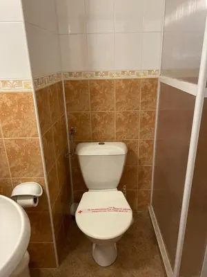 a bathroom with a white toilet and a sink at Хотел ЗОНАРИТА in Primorsko