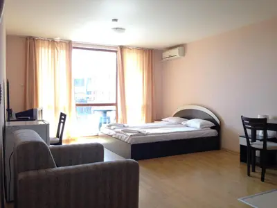 a bedroom with a bed and a couch and a chair at Apartments in Panorama Beach Vigo Nessebar in Nesebar