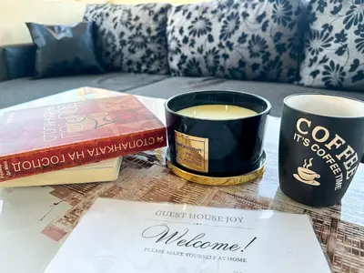 a table with two cups of coffee and a book at Апартамент Joy in Varna City