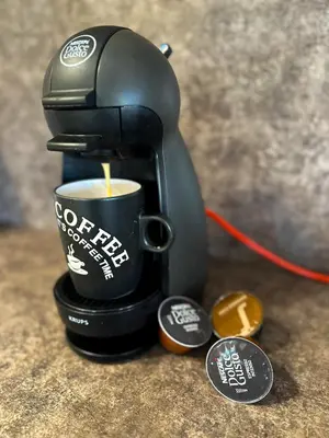 a coffee maker is making a cup of coffee at Апартамент Joy in Varna City