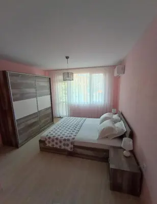 a bedroom with a large bed and a window at Apartament Lili Sozopol in Sozopol
