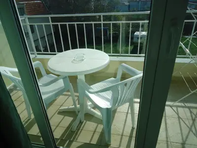 a white table and two chairs on a balcony at Pension RUSKOVI GuestHouse in Ravda